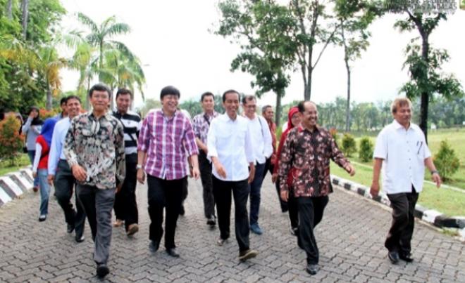 Presiden Joko Widodo saat menjadi gubernur DKI Jakarta, berjalan kaki menuju auditorium kampus Unand didampingi Rektor, Werry Darta Taifur, Helmi (Direktur Program Pascasarjana), Alex Indra Lukman (ke