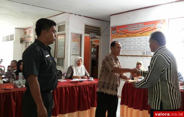 Ketua KPU Sijunjung, Taufiqurrahman menyerahkan memori serah terima jabatan pada Jasril yang dipindahkan tugas jadi Camat Lubuktarok. Sementara, Sekretaris KPU Sijunjung yang baru dijabat, Irzal Zamzami (kiri). (istimewa)