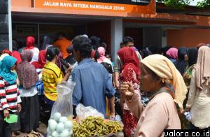 Seorang pedagang asongan asal Lubukalung, mencoba mengais rezeki saat puluhan warga Nanggalo, memproses pencairan dana bantuan PKH Tahap I 2015, Selasa (21/4/2015) sore di Kantor POS Nanggalo. (AI Mangindo Kayo/valoranews)