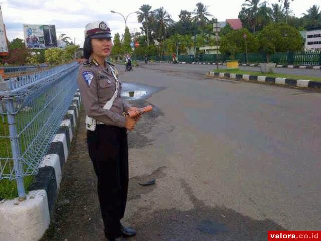 Bintara Polwan Polres Pessel, tengah mengawasi pengendara kendaraan bermotor yang melewati jalan jalur dua Kota Painan, Kamis (21/5/2015) pagi. Kawasan ini merupakan jalur tertib berlalulintas. (Lelek/Valoranews)