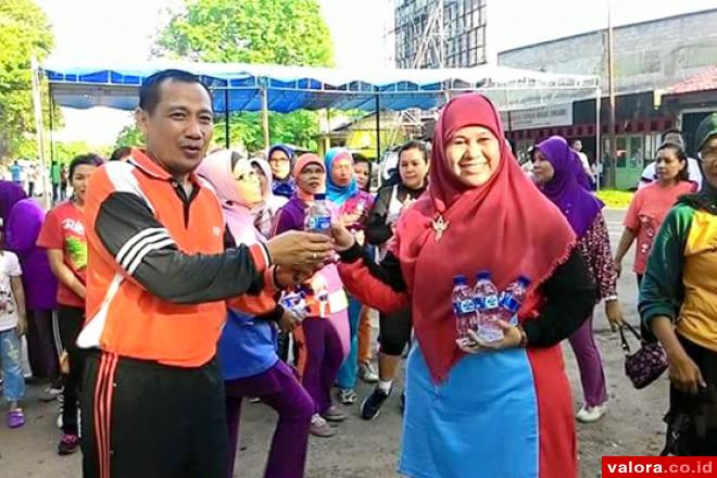 Ketua Yayasan Jantung Indonesia (YJI) Cabang Padang, Harneli Bahar di GOR Agus Salim, Minggu (31/5/2015), membagi-bagikan air dalam kemasan, saat peringatan hari tanpa tembaka sedunia tingkat Padang. (Humas Pemko Padang)