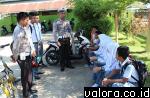 Personel Sat Lantas Polres Pessel, berdialog dengan siswa MTsN Salido, Pessel menyosialisasikan tertib berlalu lintas pada 9 Mei 2015. (Humas Polres Pessel)