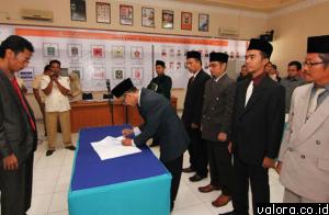 Salah seorang komisioner KPU Padang, Mahyudin, menandatangani berita acara pelantikan sebagai anggota KPU Padang periode 2014-2019 di saksikan ketua KPU Sumbar, Amnasmen. (istimewa)