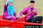 Wako Padang Mahyeldi mengayuh sampan ditemani istri, saat digelarnya lomba selaju sampan di Batang Harau, 26 Mei 2015. (humas Pemko Padang)