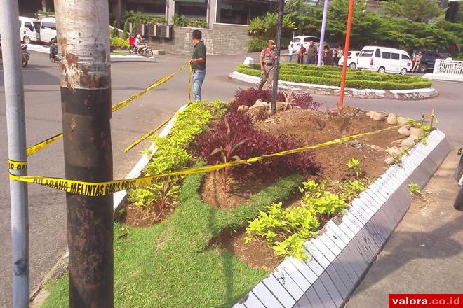 Seorang personel kepolisian dari Polresta Padang, tengah memasang garis polisi atas peristiwa perusakan taman kota di bundaran Jl Bundo Kanduang, Selasa (2/6/2015). (Humas Pemko Padang)
