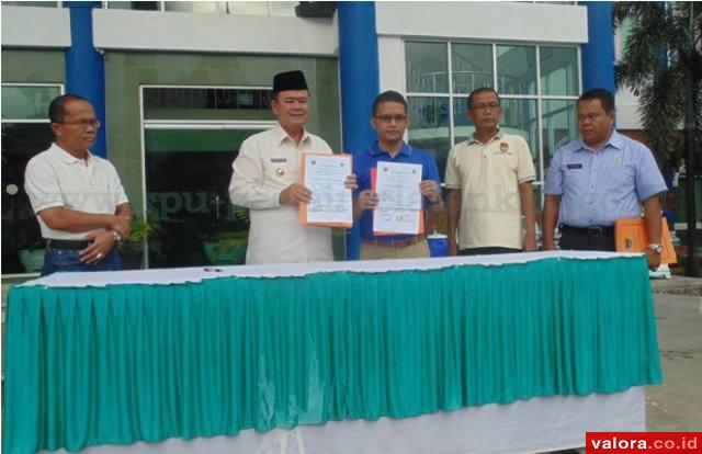 Bupati Pessel, Nasrul Abit bersama Epaldi Bahar (ketua KPU Pessel) memerlihatkan dokumen Naskah Perjanjian Hibah Daerah (NPHD) Pilkada Pessel 2015 pada 29 Mei 2015. Disetujui dana sebesar Rp13,5 miliar dari yang diajukan senilai Rp23,1 miliar. (Humas KPU