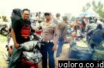 Seorang bintara Sat Lantas Polres Pessel, bersama klub Langkisau Scooter Club sembari menggelar aksi keselamatan untuk semua pengguna jalan raya, 12 Februari 2015. (istimewa)