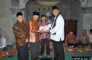 Ketua DPRD Sumbar, Hendra Irwan Rahim menyerahkan bantuan uang pada pengurus masjid di Korong Alahan Tabek, Nagari Sikucua, Kecamatan V Koto Kampung Dalam, Padangpariaman, Senin (21/5/2015) malam. (istimewa)
