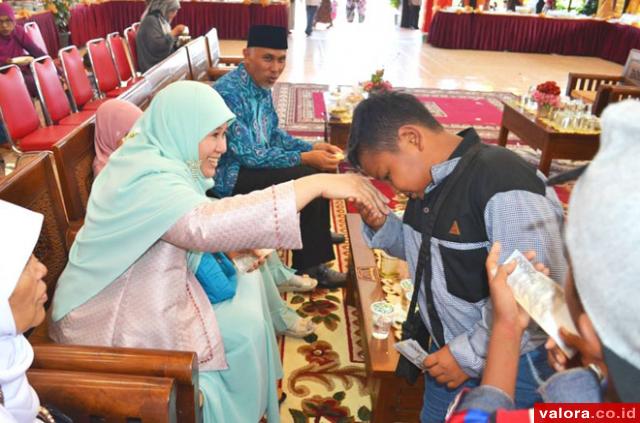 Istri Wako Padang, Harneli Bahar memberikan THR pada anak-anak yang berkunjung ke rumah dinas wako, saat open house yang digelar selama dua hari yaitu Jumat dan Sabtu (17-18/7/2015). (humas)