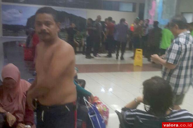 Penumpang Citilink dari Jakarta menuju Padang, terpaksa buka baju karena basah kehujanan, Minggu (2/8/2015) malam di BIM. Ini terjadi karena pesawat itu tergelincir saat mendarat. (istimewa)