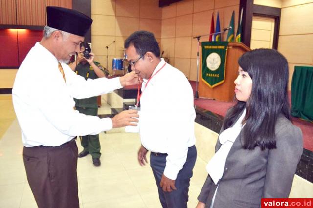 Walikota Padang memasangkan tanda peserta kepada perwakilan peserta Sosialisasi Penamaman Modal yang diadakan BPMPTSP Kota Padang, di aula STIKES Ranah Minang, Senin (5/10/2015). (humas)