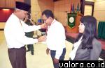 Walikota Padang memasangkan tanda peserta kepada perwakilan peserta Sosialisasi Penamaman Modal yang diadakan BPMPTSP Kota Padang, di aula STIKES Ranah Minang, Senin (5/10/2015). (humas)