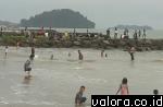 Wisatawan tengah menikmati deburan ombak Pantai Padang dengan hamparan pasir putihnya yang lembut. (vebi rikiyanto/valoranews)