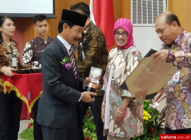 Bupati Solsel, Muzni Zakaria menerima penghargaan Swasti Saba kategori Padapa dari Dr Pattiselano Roberth Johan, Mars, Staf Ahli Bidang Desentralisasi Kesehatan dan Sertifikat Swasti Saba Padapa, di gedung Sasana Bakti Paraja, Kemendagri, Selasa (28/11/20