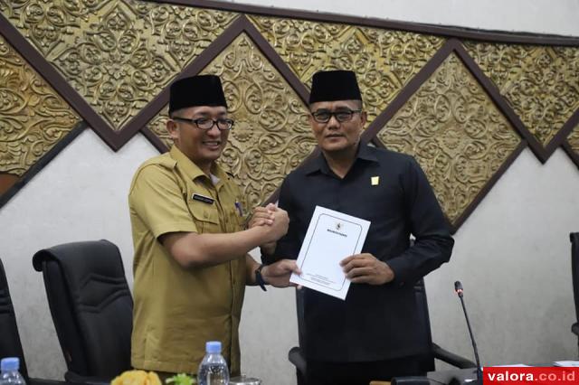 Wawako Padang, Hendri Septa menyerahkan nota penjelasan tiga Ranperda yang diajukan pemerintah pada Ketua DPRD Padang, Syafrial Kani, dalam paripurna yang digelar Senin (11/11/2019). (humas)