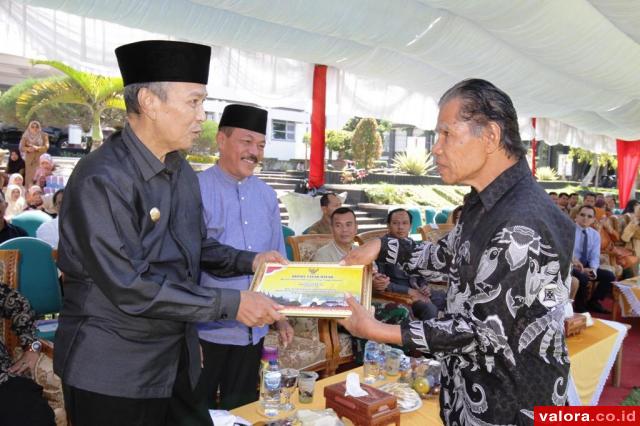 Bupati Tanahdatar, Irdinansyah Tarmizi didampingi Zuldafri Darma (Wabup) menyerahkan piagam penghargaan pada salah seorang tokoh masyarakat, usai syukuran 4 tahun memimpin Tanahdatar, di halaman kantor bupati, Senin (17/2/2020). (jheni rahmad/valoranews)