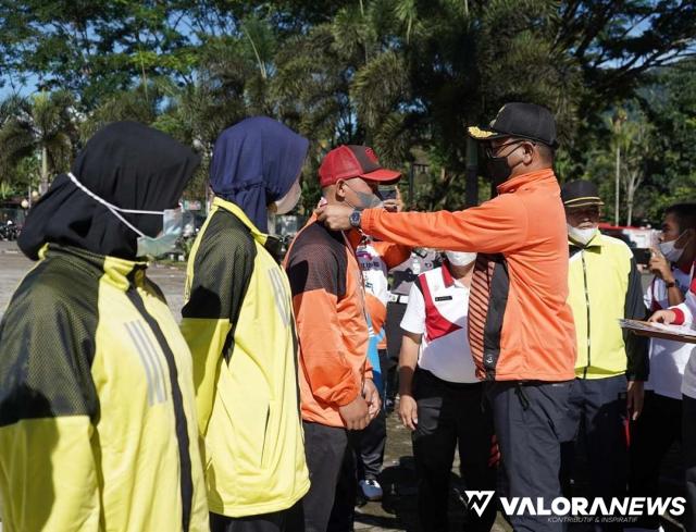 Bupati Solsel, Khairunnas mengalungkan medali pada atlet pelajar berprestasi di Solok Selatan, usai upacara peringatan Haornas di halaman kantor bupati, Timbulun, Rabu pagi. (humas)