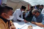 Wali Kota Bukittinggi, Erman Safar meneliti berkas pengajuan pinjaman modal kerja dari seorang pedagang, saat peluncuran Tabungan Utsman oleh BPRS Jam Gadang, di jalan di bawah Jembatan Gatuang, Pasar Bawah, Rabu pagi. (hamriadi)