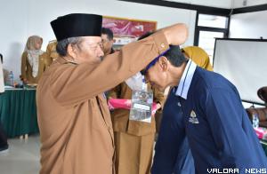 Bupati Agam, Andri Warman memasangkan tanda peserta pelatihan pengelolaan homestay, di Tabek Pamandian Sikabu, Kecamatan IV Koto, Senin. (humas)