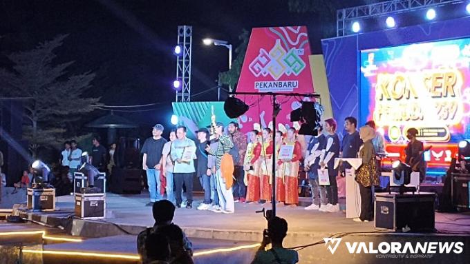 Kadispora Pekanbaru, Hazli Fendrianto menyerahkan piala dari berbagi lomba yang telah digelar, pada malam puncak Konser Pemuda 2023, Sabtu malam. (humas)