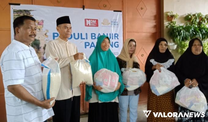 Wakil Ketua DDII Sumbar, H Anisral bersama kelompok masyarakat korban banjir Kota Padang, menerima bantuan paket Sembako dari hamba Allah melalui Laznas Dewan Da&#039;wah Pusat. (*)