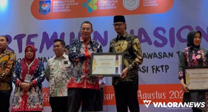 Ketua Umum Adinkes, M Subuh menyerahkan penghargaan pada Wali Kota Bukittinggi, Erman Safar yang dinilai berhasil optimalkan dana kelurahan/desa dalam menanggulangi wabah ATM di Makasar, 1 Agustus 2023. (humas)
