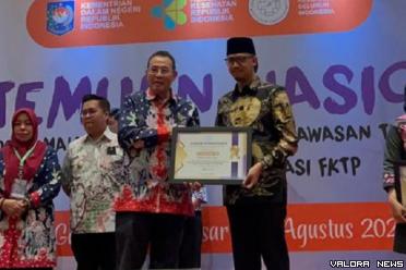 Ketua Umum Adinkes, M Subuh menyerahkan penghargaan pada Wali Kota Bukittinggi, Erman Safar yang dinilai berhasil optimalkan dana kelurahan/desa dalam menanggulangi wabah ATM di Makasar, 1 Agustus 2023. (humas)