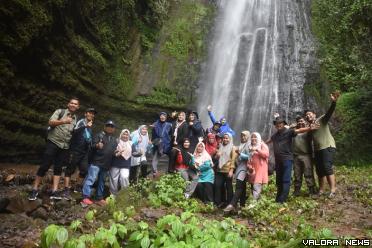 Ketua TP PKK Agam, Yenni Andri Warman, Rahmad Fajri (Camat Malalak), Abdul Hanif (Wali Nagari Malalak Timur) dan rombongan, foto bersama dengan latar belakang Burai-burai Batang Marambuang, Ahad. (humas)