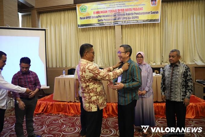 Ketua DPRD Padang, Syafrial Kani memasangkan tanda peserta Bimtek Pendalaman Tugas Pimpinan dan Anggota DPRD Padang pada salah seorang peserta dari Fraksi PDIP, Christian Rudi Kurniawan. (humas)