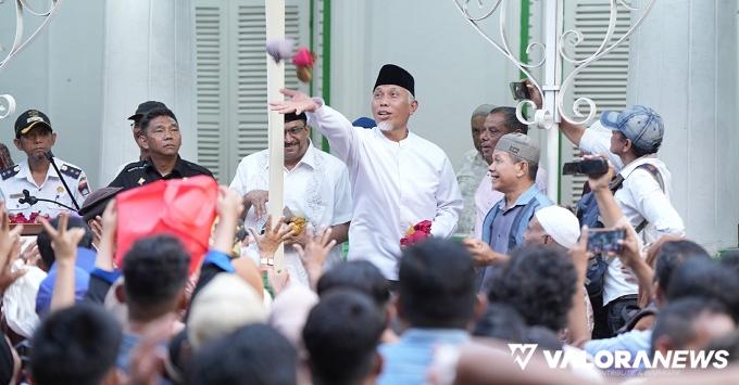 Gubernur Sumbar, Mahyeldi ikut menyerakan bungkusan berisi gula pasir pada event tradisi Serak Gulo di kawasan Kompleks Masjid Muhammadan, Pasa Gadang, Kota Padang, Rabu sore. (humas)