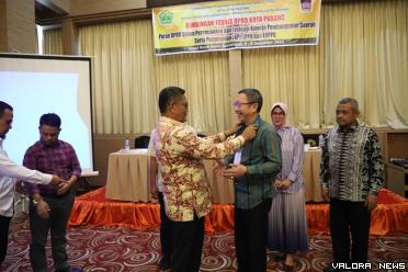 Ketua DPRD Padang, Syafrial Kani memasangkan tanda peserta Bimtek Pendalaman Tugas Pimpinan dan Anggota DPRD Padang pada salah seorang peserta dari Fraksi PDIP, Christian Rudi Kurniawan. (humas)
