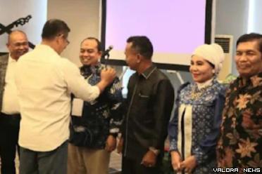 Ketua DPRD Padang, Syafrial Kania memasangkan tanda peserta Bimtek pendalaman tugas pimpinan dan anggota DPRD Padang di Pekanbaru, tanggal 18-20 Juli 2024. (humas)