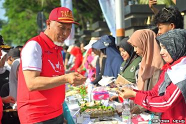Gubernur Sumbar, Mahyeldi menikmati sajian Lamang Tapai usai membuka Festival Kuliner Minangkabau dan Senam Bersama di salah satu ruas jalan utama di Kota Padang, Ahad. Lamang Tapai merupakan kuliner khas daerah kelahiran Mahyeldi, Kamang. (humas)