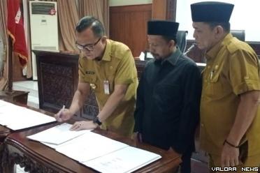Pjs Wako Bukittingi, Hani Syopiar Rustam menandatangani berita acara persetujuan KUA PPAS Tahun 2025 dalam rapat paripurna DPRD Bukittinggi, Senin malam. Penandatanganan ini disaksikan pimpinan DPRD. (humas)