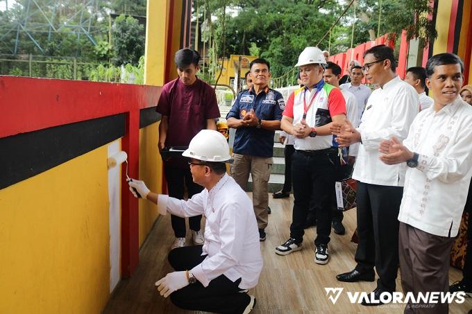 Pjs Wali Kota Bukittinggj, Hani Syopiar Rustam melakukan pengecatan ulang Jembatan Limpapeh yang merupakan CSR Nipon Paint, di Bukittinggi, Jumat. (hamriadi)