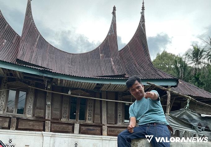 Penggiat Satuan Tenaga Konselor Kepariwisataan (SANAK) Sumatera Barat, Muhammad Fadhli dengan latar belakang rumah gadang Minang khas Simpang Sugiran yang tak seperti lazimnya rumah adat Minang. (istimewa)