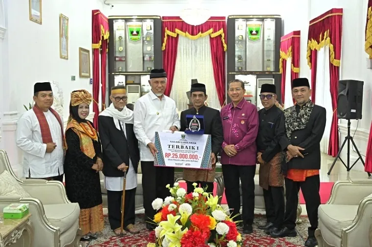 Gubernur Sumbar, Mahyeldi menyerahkan penghargaan pada wali nagari terbaik dalam penerapan ABS SBK di istana gubernuran, Jumat. (humas)