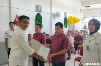 Kepala Lapas Padang, Junaidi Rison menyerahkan surat keputusan remisi pada perwakilan warga binaan dalam perayaan natal sederhana yang digelar di Gereja Lapas Padang, Rabu. Acara ini dihadiri pejabat struktural dan jajaran Lapas Padang. (veri rikiyanto)