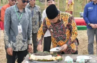 Bupati Agam, Andri Warman memotong nasi lamak pada perayaan milad ke-1 Sanggar Seni Satangkai Boneh, di Jorong Sungai Tanang Ketek, Nagari Sungai Tanang, Kecamatan Banuhampu, Ahad. (humas)