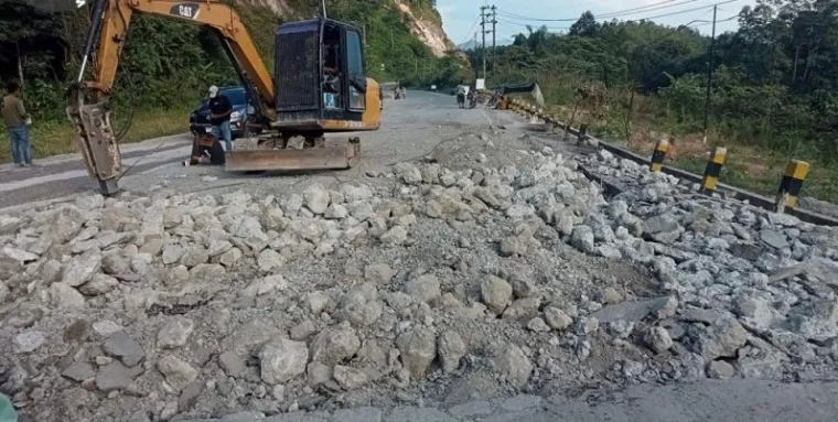 Pekerja tengah memperbaiki jalan yang rusak di kilometer 106-107 dan di dekat gerbang perbatasan Sumbar dan Riau. (humas)