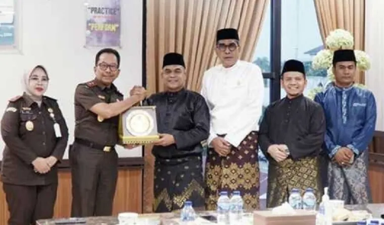 Ketua DPRD Riau, Kaderismanto didampingi para wakil ketua, Parisman Ihwan, Ahmad Tarmidzi dan Budiman bertukar cenderamata usai pertemuan silaturahmi di ruang kerja Kajati Riau, Akmal Abbas, Senin. (humas)