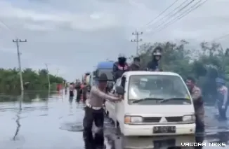 Petugas Satlantas Polres Pelalawan membantu mendorong mobil yang mogok di KM 83 Jalan Lintas Timur (Jalintim), di Kecamatan Pangkalan Kuras, Kabupaten Pelalawan, Jumat siang. (humas)