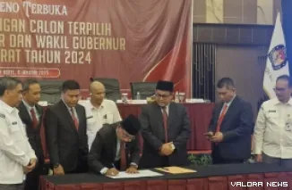 Ketua KPU Sumbar, Surya Efitrimen menandatangani Surat Keputusan No 3 Tahun 2025 tentang Penetapan Calon Gubernur dan Wakil Gubernur Terpilih Tahun 2024, usai rapat pleno terbuka, Kamis. (humas)