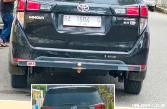 Mobil Operasional Ketua KPU Pessel saat parkir di depan Mapolres setempat, pukul  11:41 WIB, Senin (13/1/2025). Dibawahnya, adalah foto plat nomor asli (plat merah). FOTO: tusrisep