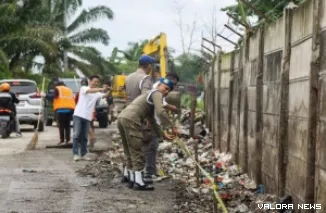 Personel Satpol PP Pekanbaru memasang tanda larangan membuang sampah di salah satu bahu jalan, Jumat. (humas)
