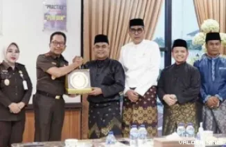 Ketua DPRD Riau, Kaderismanto didampingi para wakil ketua, Parisman Ihwan, Ahmad Tarmidzi dan Budiman bertukar cenderamata usai pertemuan silaturahmi di ruang kerja Kajati Riau, Akmal Abbas, Senin. (humas)