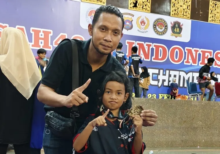 Taekwondoin usia dini Dojang HTC Fighter, Raisa Aulia bersama pelatihnya, Nanda Fajar Chakti foto bersama usai meraih medali emas event SAH484T INDONESIA Nasional Taekwondo Championship 2025 di GOR UNP, Ahad. (istimewa)