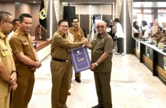 Sekdaprov Sumar, Yozawardi Usama Putra serahkan penghargaan sebagai kabupaten/kota peduli HAM Tahun 2025 pada Sekda Agam, Edi Busti disela rapat Forum Perangkat Daerah di aula kantor gubernur Sumbar, di Padang, Selasa. (humas)