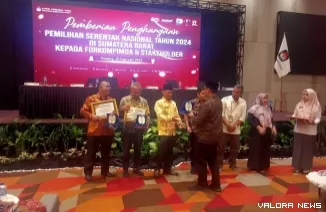 Ketua Divisi Teknis KPU Sumbar, Ory Sativa Syakban menyerahkan penghargaan pada gubernur dan Forkopimda pada diskusi terpumpun evaluasi penyusunan laporan pelaksanaan pemilihan 2024, Kamis. (humas)
