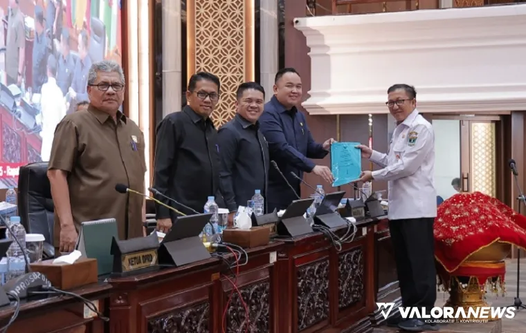 Pj Sekdaprov Sumbar, Yozawardi menyerahkan nota jawaban gubernur terhadap pandangan umum anggota DPRD Sumbar terhadap Ranperda SPBE ke pimpinan rapat, Nanda Satria pada rapat paripurna, Jumat. (humas)